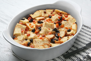 Freshly baked bread pudding in casserole dish on wooden table
