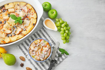 Freshly baked bread pudding in casserole dishes on wooden table