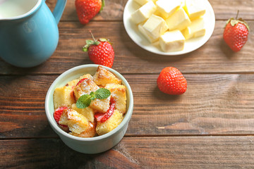 Delicious bread pudding with strawberry and mint on wooden table