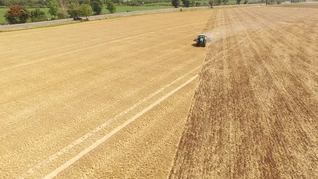 Aerial of a tractor on a acre. Grubbering the field. Europe, Germany. Near Cologne. July 