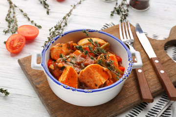 Bowl with delicious chicken cacciatore on wooden board