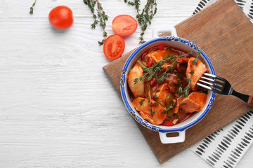 Bowl with delicious chicken cacciatore on wooden board