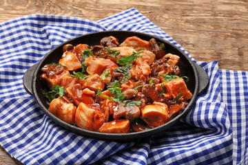 Delicious chicken cacciatore in frying pan on kitchen table