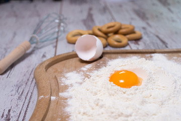 Baking concept. Sprinkled flour and eggs on wooden cutting board, cooking ingredients. Prepare for making yeast dough. Top view, copy space