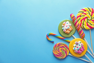 Composition with tasty lollipops on color background