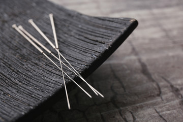 Needles for acupuncture and special stand on grey background, closeup