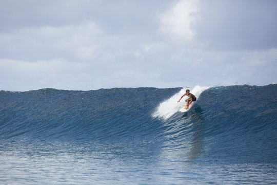 Surfer riding large scale wave, Tahiti, South Pacific 