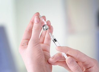 Hands of doctor with syringe and medicine in clinic, closeup