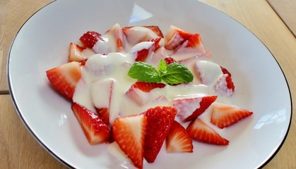 Dessert with strawberries, vanilla cream and decorated with a mint leaf
