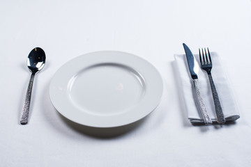 white plate with a knife and fork on a white background