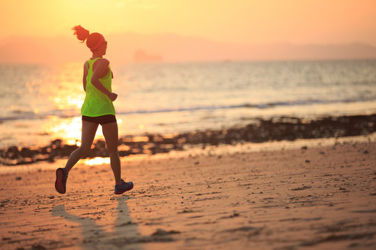 Healthy lifestyle young fitness woman running at morning beach