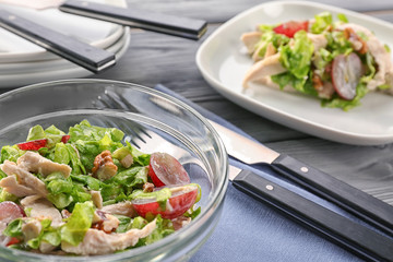 Plate with chicken salad and grapes on table