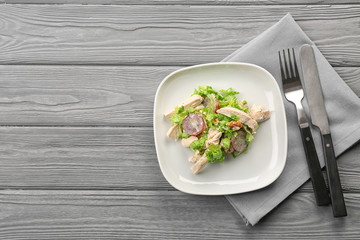 Plate with chicken salad and grapes on table