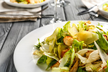 Plate with chicken salad on table