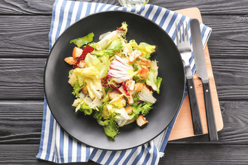 Plate with chicken salad on table