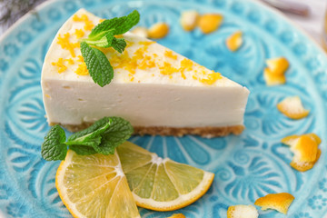 Tasty cheesecake slice with lemons on plate