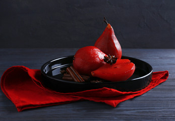 Pears poached in red wine as dessert on plate