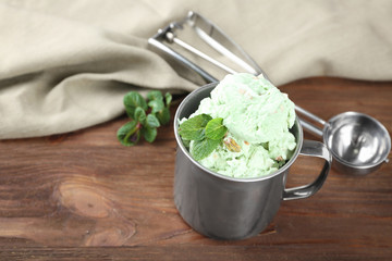 Metal cup with pistachio ice cream on table