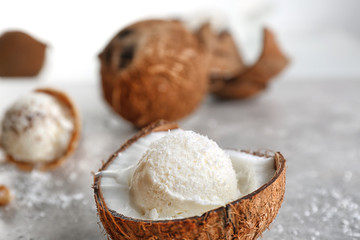 Fresh ball of ice cream in half of coconut on kitchen table