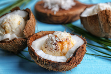 Halves of coconut with fresh ice cream on color background