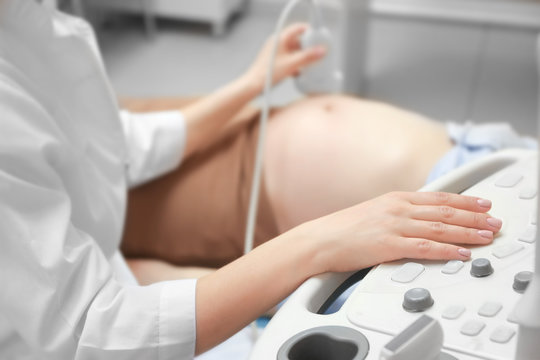 Pregnant woman undergoing ultrasound scan in modern clinic