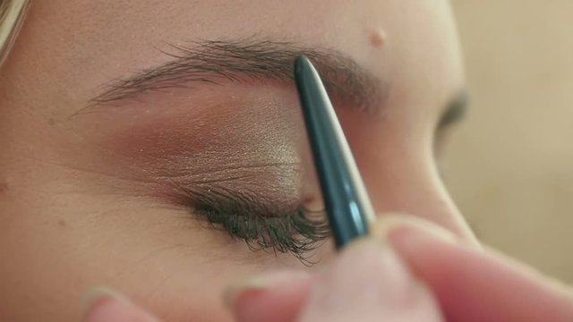 Makeup artist paints the eyebrows, doing eyebrow correction