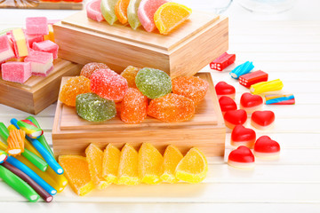 Composition of tasty jelly candies on wooden background