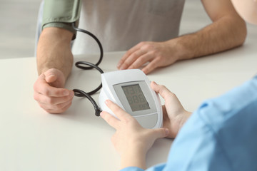 Medical assistant measuring patient's blood pressure, closeup