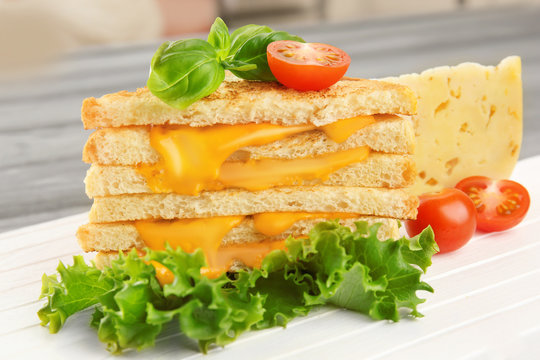 Tasty sandwich with cheese on wooden board