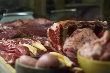 Different pieces of raw meat in a butcher window display