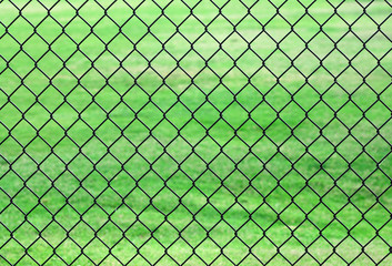 chain link fence in front of green lawn