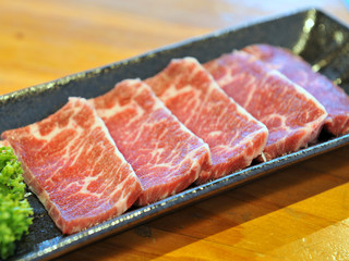Fresh raw sliced beef on black platter