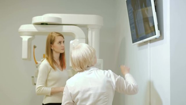 Professional female doctor reading x-ray film of brain and on the phone 4k