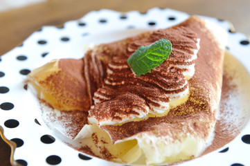 Creamy cake with chocolate and mint leaf