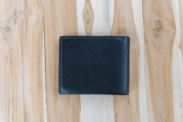 Black leather wallet on wooden background