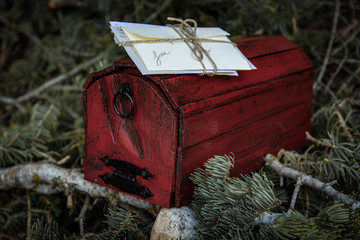 Wooden mailbox with a bundle of letters resting on top nestled in a woody environment