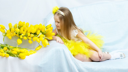 The girl bowed her head over the flowers and sniffs them.