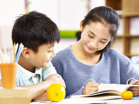 asian elementary schoolgirl and school boy studying together