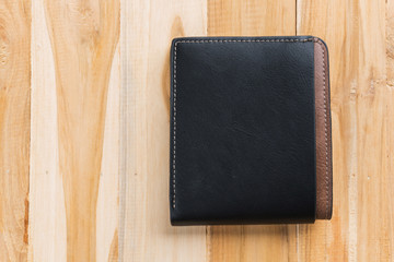 Black leather wallet on wooden background