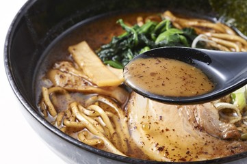 Ramen soup with noodle and white cabbage in black bowl
