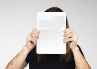 Woman is holding a digital device on her face