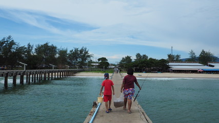 two children help their family by carry jellyfish in plastic bag to make dry food