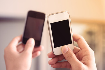Hand holding two smart phone to sharing and link data