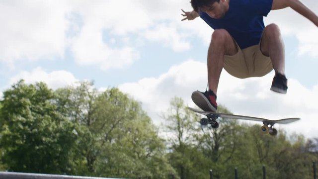 Skateboarder in a park performing tricks, in slow motion