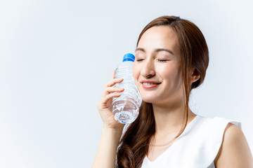 hydration concept. a young woman cooling her face with a bottle of water.
