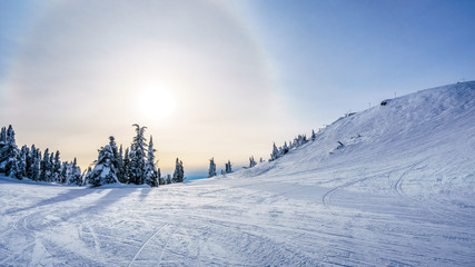 Obraz premium Sun trying to break through the clouds in the high alpine of the ski resort of Sun Peaks in the Shuswap Highlands of central British Columbia, Canada
