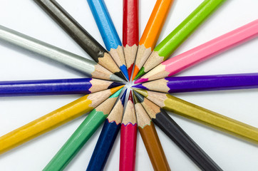 Color pencils in arrange in color wheel colors on  white paper  background