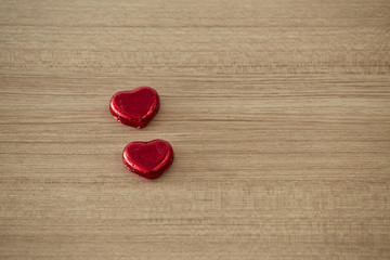 Chocolate heart wrapped in red on wood. valentine concept