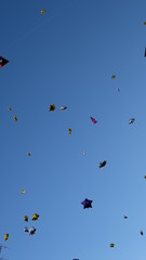 Small star shaped balloons floating in blue sky