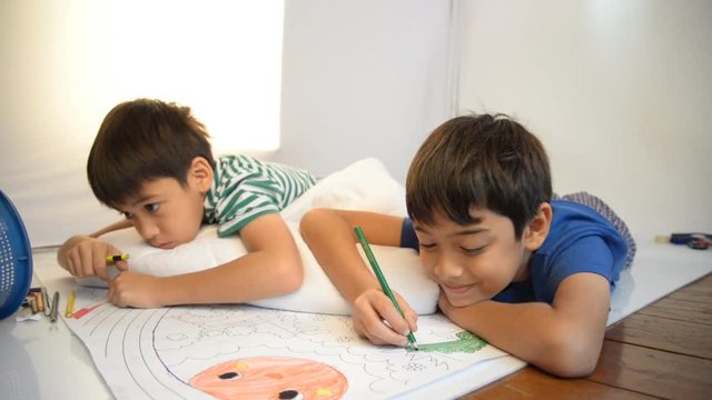 Little boy draw and painting pencil color on the paper home activities 